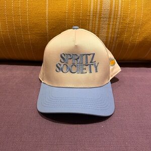Spritz Society snapback trucker hat with a beige front and light blue brim